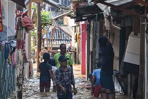 Beeld van een ondergelopen straatje in de Indonesische hoofdstad Jakarta. Onder andere vanwege de bele onderstromingen die de hoofdstad teisteren, zoekt de regering naar een andere locatie voor een hoofdstad. beeld AFP, Bay Ismoyo