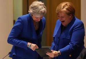 Premier May (l.) in een onderonsje met kanselier Merkel. beeld EPA, KENZO TRIBOUILLARD