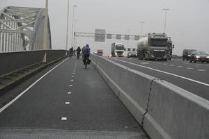 Betonblokken scheiden fietsers van het snelwegverkeer dat bij Vianen de Lek oversteekt. De boogbrug ernaast, die op de nominatie staat voor sloop, zou een veel veiliger fietsroute vormen, menen Fietsersbond en plaatselijke politieke partijen. beeld André Bijl