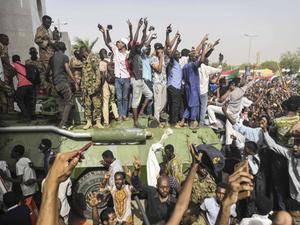 Vreugde in de Sudanese hoofdstad Khartoem, donderdag, nadat bekend was geworden dat president Omar al-Bashir zou aftreden. beeld AFP