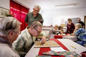 De blinde Wim de Vogt buigt zich over een sudoku. Hij bezoekt het oogcafé in Dordrecht. Daar zoeken elke twee weken blinde en slechtziende ouderen elkaar op.  beeld Dirk Hol