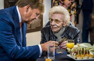 Koning Willem-Alexander in gesprek met een hoogbejaarde vrouw. beeld ANP