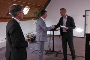 Jan Jaap Karsten van uitgeverij Groen overhandigt het boek aan dr. Nathan Witkamp.  beeld RD
