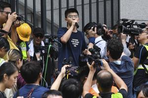 De prodemocratische activist Joshua Wong (22) sprak eind juni honderden betogers toe voor het politiehoofdkwartier in Hongkong. beeld AFP, Anthony Wallace