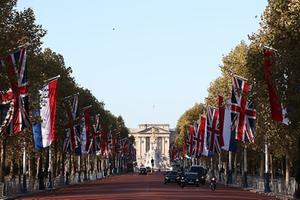 Grote Nederlandse en Britse vlaggen omlijsten The Mall, de route in Londen die de paradeplaats Horse Quards Parade verbindt met Buckingham Palace, het koninklijke paleis. Even na het middaguur zal koningin Elizabeth II dinsdag haar collega uit Nederland en zijn vrouw ontvangen. beeld AFP