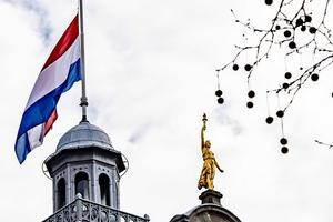 Op het Rotterdamse stadhuis hangt de vlag halfstok voor de slachtoffers van de aanslag in de tram in Utrecht. beeld ANP