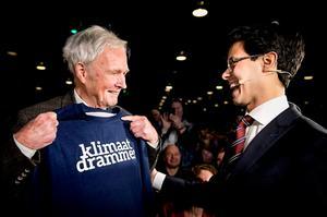 Fractievoorzitter Tweede Kamer Rob Jetten (R) biedt Jan Terlouw een klimaatdrammertrui aan tijdens het 109e partijcongres van D66. beeld ANP