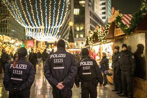 Politieagenten lopen over de heropende kerstmarkt in Berlijn, drie dagen na de aanslag op 19 december 2016. beeld EPA