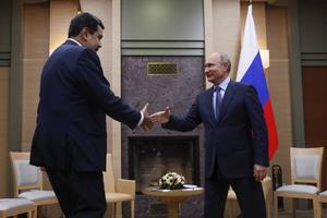 President Maduro (l.) van Venezuela reikt de hand aan zijn Russische collega Poetin tijdens zijn bezoek aan Moskou in december.  beeld EPA, Maxim Shemetov