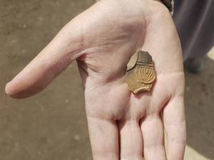 Een olielamp gedecoreerd met een afbeelding van een negenarmige menora. beeld Anat Rasiuk, Israëlische Oudheidkundige Dienst