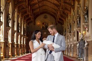 Prins Harry en zijn vrouw Meghan hadden vooraf twijfel gezaaid of er wel een fotomoment zou komen. Maar het kwam. Woensdag poseerde het gezinnetje in de oude St. Georgzaal in Windsor Castle.  beeld AFP, Dominic Lipinski
