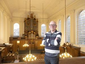 Nigel Lamb op de galerij van de evangelisch-lutherse kerk in Den Haag. Achter hem als blikvanger het Bätzorgel uit 1762. „Ik behandel het instrument als een soort kind.” beeld Sjaak Verboom