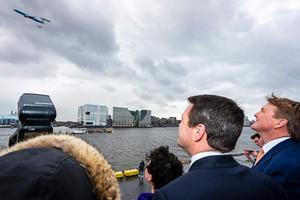 Koning Willem-Alexander kijkt naar een vliegshow met een laagvliegende Boeing van KLM die wordt begeleid door vier F-16’s. beeld ANP
