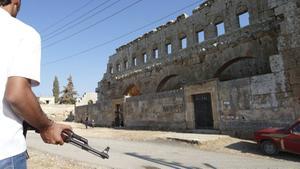 Islamitische rebellen stellen alles in het werk om ook de laatste christenen uit de Syrische provincie Idlib te verjagen. Foto: Syrische rebel bij een eeuwenoude byzantijnse kerk in het noordwesten van Idlib. beeld AFP, Herve Bar