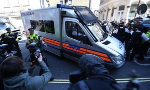 Een arrestantenbusje met daarin Julian Assange. beeld EPA