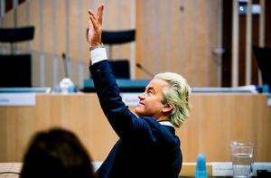 Geert Wilders zwaait naar de publieke tribune in de rechtbank van het Justitieel Complex Schiphol voorafgaand aan de hervatting van het proces tegen hem. beeld ANP
