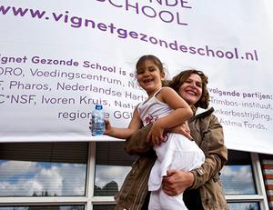 Volksgezondheidminister Edith Schippers in 2012 samen met een leerling van de Anne Frankschool in Den Haag, tijdens de lancering van het Vignet Gezonde School. Het vignet is een waardering voor scholen die structureel bezig zijn met gezondheid. beeld ANP, Ed Oudenaarden