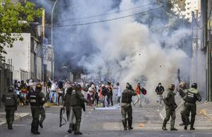 Betogers botsen met ordetroepen in de Venezolaanse hoofdstad Caracas. De Verenigde Staten hebben president Maduro gewaarschuwd het leger niet tegen demonstranten in te zetten. In bedekte termen dreigde Washington met militair ingrijpen in het Zuid-Amerikaanse land. beeld AFP, Yuri Cortez