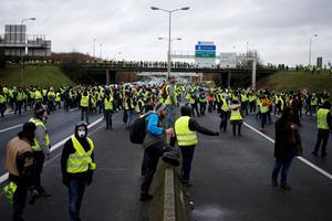 Franse activisten in gele hesjes blokkeren zaterdag een snelweg in de buurt van de noordwestelijke stad Caen. beeld AFP, Charly Triballeau