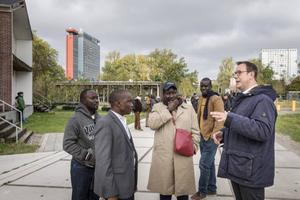 Gijsbert Korevaar (r.) leidt een groep collegadocenten rond op de campus van de TU Delft. beeld RD, Henk Visscher