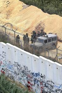 Aan de noordgrens staat Israël er praktisch alleen voor. Foto: Israëlische soldaten bij de bijna voltooide, tien meter hoge muur die Israël en Libanon strikter van elkaar moet scheiden. beeld AFP, Mahmoud Zayyat