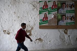 Een man passeert affiches van politieke partijen in Setenil de las Bodegas. beeld AFP