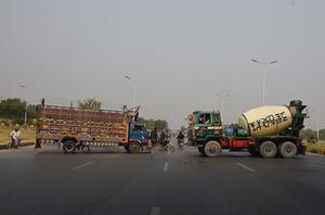 Vrachtwagens blokkeren een hoofdweg naar de Pakistaanse hoofdstad Islamabad. Ze protesteren daarmee tegen de vrijlating van Asia Bibi, een christelijke vrouw die in 2009 gevangen werd genomen omdat zij de profeet Mohammed beledigd zou hebben. beeld AFP