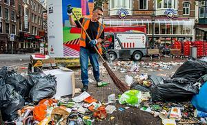 Een schoonmaker veegt de straten schoon na drie dagen staken. beeld ANP