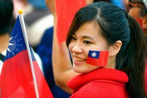 Een aanhanger van de Kwomintang-partij (KMT) toont haar vreugde nadat bekend was geworden dat deze partij op Taiwan de lokale verkiezingen had gewonnen. beeld AFP, Chris Stowers