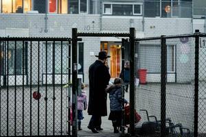Een ouder brengt zijn kinderen naar de orthodox-Joodse school het Cheider in Amsterdam. De school ligt onder een vergrootglas van de onderwijsinspectie. beeld ANP, Robin van Lonkhuijsen