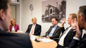 Koning Willem-Alexander luistert naar burgemeester Houben van Voerendaal die vertelt over zijn ervaringen met dreiging. beeld ANP