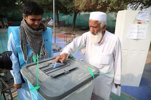Een Afghaanse man levert zijn stembiljet in in Jalalabad, Afghanistan. beeld EPA