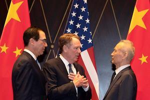 Handelsvertegenwoordiger van de Verenigde Staten Robert Lighthizer (midden) praat met de Chinese vice-premier Liu He (rechts) terwijl de Amerikaanse minister van Financiën Steven Mnuchin (links) toeziet. beeld AFP, Han Guan