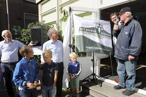 Vaste bezoeker Theo Secrève (uiterst rechts) mocht zaterdag het nieuwe logo onthullen van inloophuis Het Kompas, dat is verhuisd van de Apeldoornselaan in Den Haag naar de Keizerstraat in Scheveningen. beeld Dick Teske
