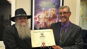 Kenneth Talbot van Whitefield Theological College in Florida overhandigt het eredoctoraat aan Gary Bates, directeur van de Amerikaanse vestiging van Creation Ministries International (CMI). beeld CMI