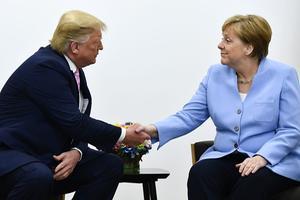 De leiders van Amerika en Duitsland schudden elkaar de hand. beeld AFP