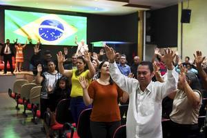 Gelovigen bidden in een evangelicale gemeente in Brasilia voor het herstel van Jair Bolsonaro die in 2018 tijdens de campagne voor de presidentsverkiezingen werd neergestoken. beeld AFP, Evaristo Sa