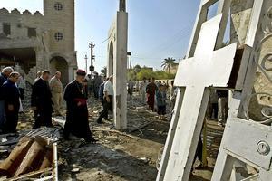 Iraakse christenen inspecteren een kerk die getroffen werd door een autobomaanslag. beeld AFP, Ahmad al-Rubaye