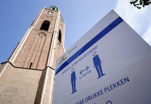 „Het kabinet dient de anderhalvemeternorm zo snel mogelijk af te schaffen.” Foto: In-structiebord bij Grote of Sint-Jacobskerk in Den Haag. beeld ANP, Bart Maat