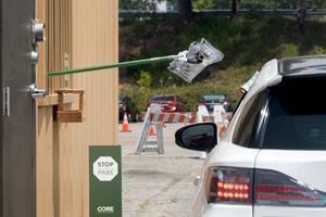 Een automobilist ontvangt in Los Angeles, Californië, een pakketje met materiaal om zich te testen op corona. Het aantal besmettingen stijgt sterk in de Amerikaanse deelstaat. beeld AFP, Valerie Macon