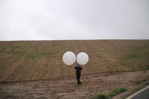 Eric Foley, medeoprichter van de organisatie Voice of the Martyrs in Korea, laat ballonnen met Bijbels op. Ondanks een recent verbod van de Zuid-Koreaanse autoriteiten op deze lanceringen, gaat Foley door. beeld SDOK