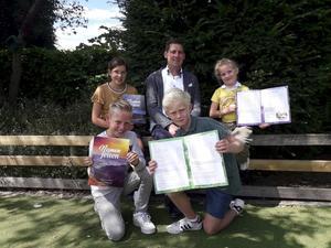 Schoolleider Adrian Romijn met enkele leerlingen die de herziene versie van de godsdienst methode Namen en feiten in handen hebben. beeld Eben-Haëzerschool