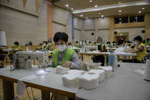 Vrijwilligers werken in de Zuid-Koreaanse stad Seoul aan mondkapjes ter bestrijding van het coronavirus, vrijdag. beeld AFP, Ed Jones
