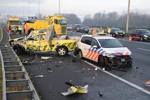 Schade aan een politieauto en een voertuig van een weginspecteur nadat een vrachtwagen ze aanreed. beeld ANP