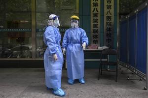 Medisch personeel in Wuhan wacht reizigers op om hen te testen op besmetting met het coronavirus. Ook al is de lockdown daar grotendeels voorbij, de vrees voor een nieuwe uitbraak leidt tot aanhoudende checks en controles.  beeld AFP, Hector Retamal