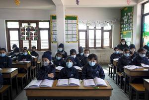 Schoolkinderen in Bkaktapur, Nepal, dragen een masker tegen besmetting met het coronavirus. Sinds de Napalese autoriteiten een besmetting met het virus constateerden in de stad Kathmandu zijn scholieren verplicht er één te dragen. beeld EPA, Narendra Shrestha