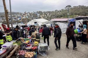 In een kamp op het Griekse eiland Lesbos liepen mensen donderdag langs kraampjes. beeld AFP, Manolis Lagoutaris