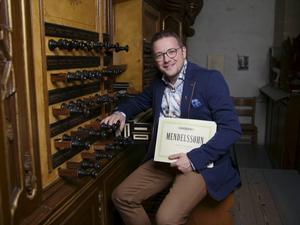 De Urker organist Minne Veldman achter de klavieren van het Hinszorgel in de Kampense Bovenkerk. beeld Klomp Creative