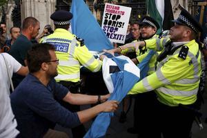 Voor- en tegenstanders van brexit botsten woensdagavond in de buurt van Downingstreet in Londen. De politie moest eraan te pas komen om de groepen uit elkaar te halen. Het besluit van de premier om het parlement op te schorten, lokte veel emotie uit.  beeld Reuters, Henry Nicholls