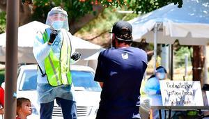 Een vrijwilliger wijst de weg naar een mobiele post voor coronatesten in Los Angeles. beeld AFP